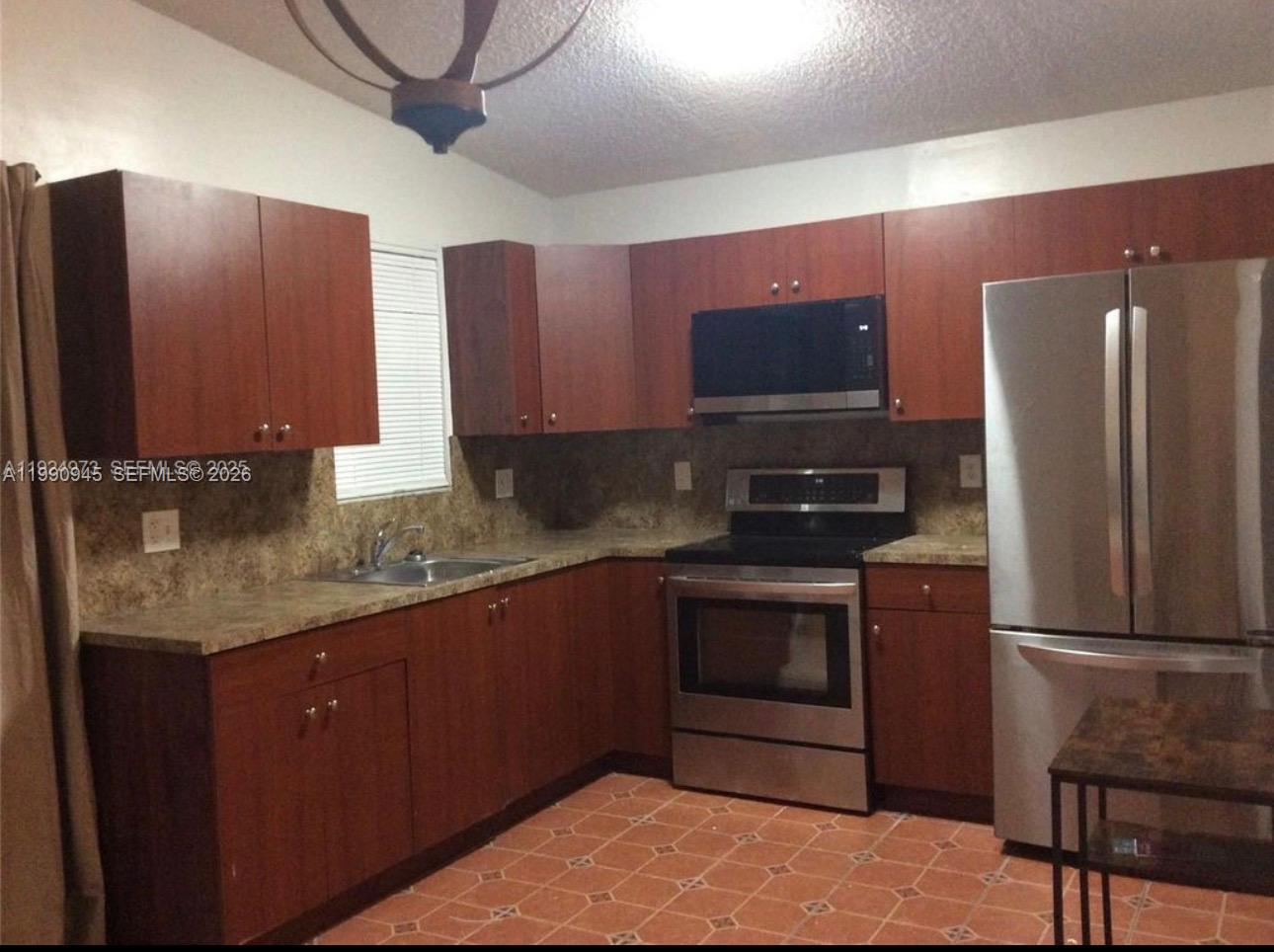 28002 Southwest 140th Court Homestead, FL 33033 - Photo 10 of 12 a kitchen with stainless steel appliances granite countertop a refrigerator stove and sink