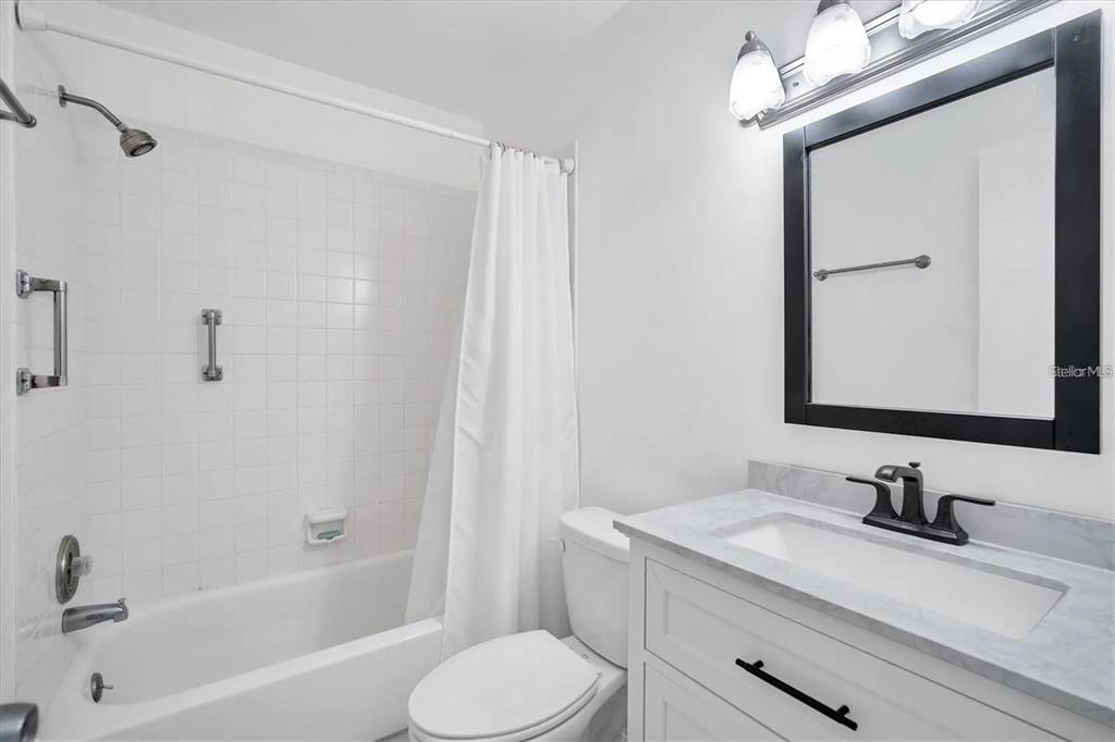 1624 Stickney Point Road, Unit 108 Sarasota, FL 34231 - Photo 12 of 39 a bathroom with a granite countertop sink toilet and shower