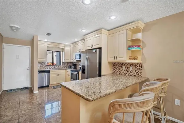 a kitchen with cabinets stainless steel appliances and a counter space