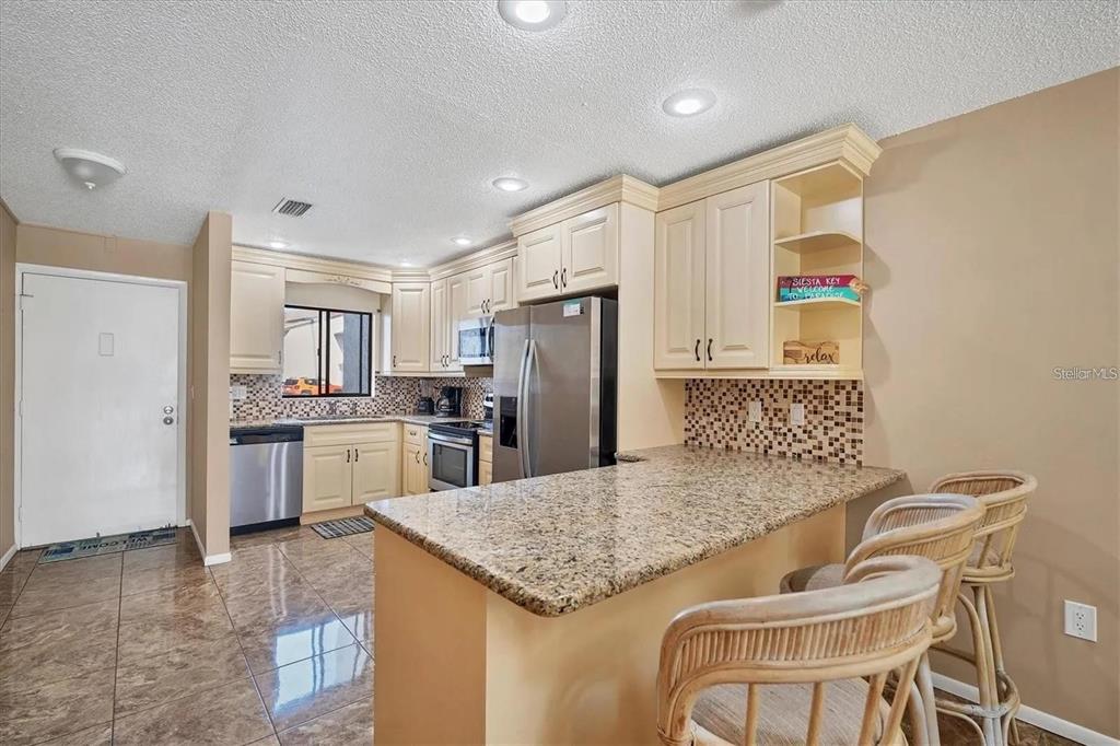 1624 Stickney Point Road, Unit 108 Sarasota, FL 34231 - Photo 6 of 39 a kitchen with a refrigerator a sink and a refrigerator