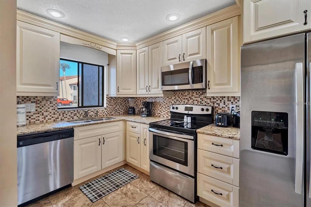 1624 Stickney Point Road, Unit 108 Sarasota, FL 34231 - Photo 7 of 39 a kitchen with cabinets stainless steel appliances and a counter space