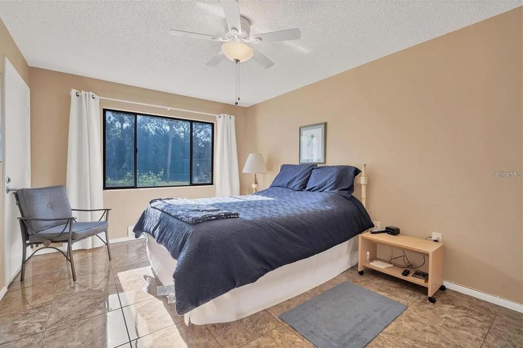 1624 Stickney Point Road, Unit 108 Sarasota, FL 34231 - Photo 9 of 39 a bedroom with a bed and chair