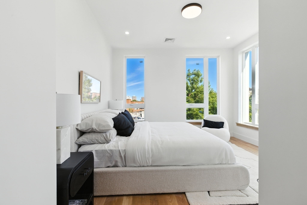 58 Kent, Unit 303 Brookline, MA 02445 - Photo 28 of 41 a bedroom with a bed and a large window