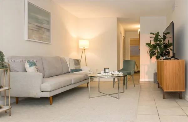 a living room with furniture a lamp and a potted plant