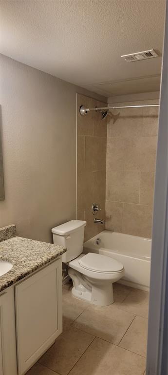 516 East Hazelwood Street, Unit A Princeton, TX 75407 - Photo 11 of 13 Bathroom with a textured ceiling, vanity, light tile patterned flooring, and washtub / shower combination