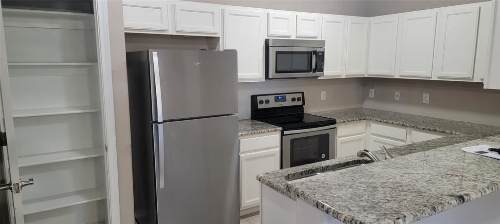 516 East Hazelwood Street, Unit A Princeton, TX 75407 - Photo 3 of 13 Kitchen featuring stainless steel appliances, and white cabinets