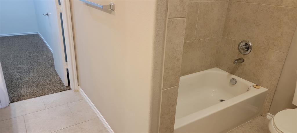 516 East Hazelwood Street, Unit A Princeton, TX 75407 - Photo 8 of 13 Bathroom featuring carpeted closet, tile patterned floors, and tub / shower combination