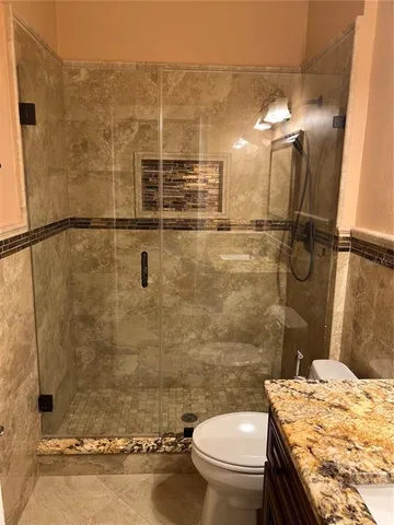 a bathroom with a granite countertop sink toilet and shower