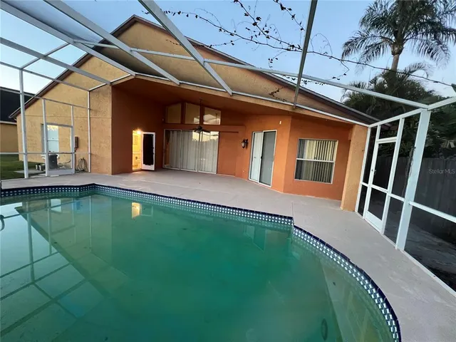 a view of a house with pool and sitting area