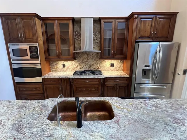 a kitchen with stainless steel appliances granite countertop a stove refrigerator and cabinets