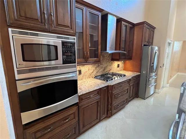 a kitchen with granite countertop wooden cabinets and stainless steel appliances