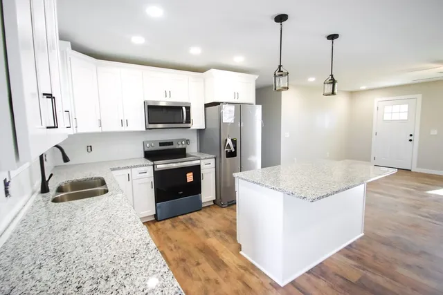 a kitchen with stainless steel appliances granite countertop a sink stove and refrigerator