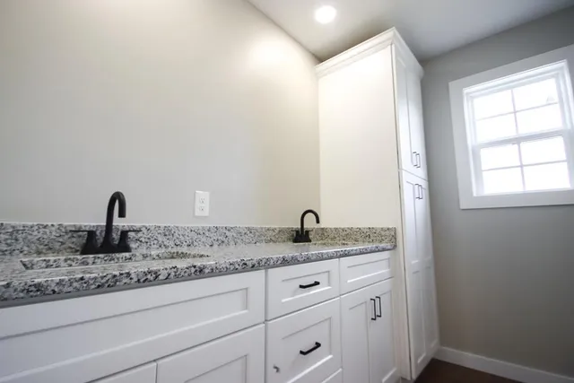 a bathroom with a granite countertop sink and a mirror