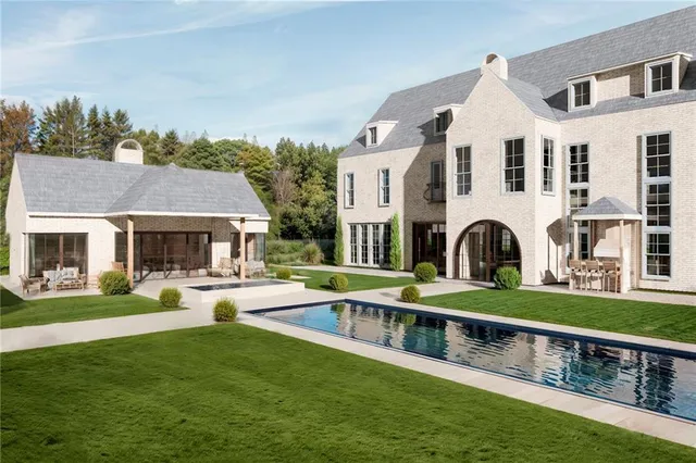 a front view of a house with garden and a yard