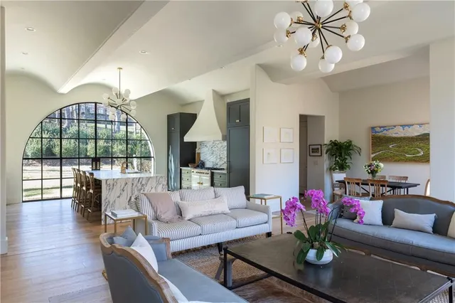 a living room with furniture dining table and a chandelier