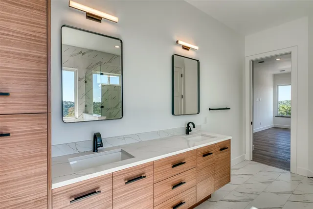 a bathroom with double vanity sinks and a mirror