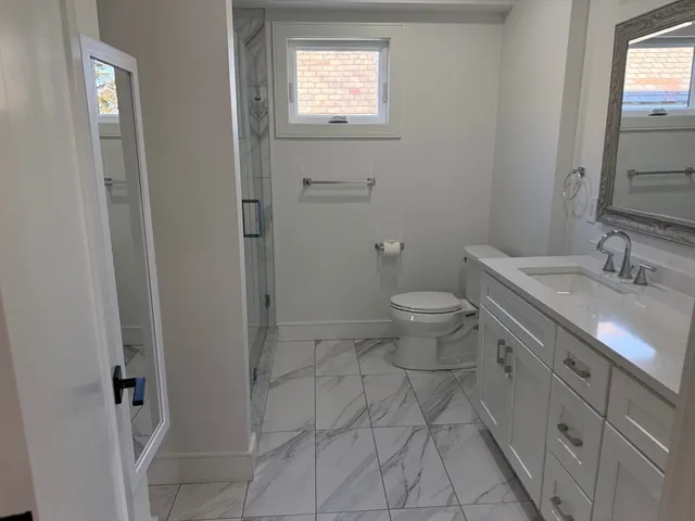 a bathroom with a granite countertop sink toilet and shower