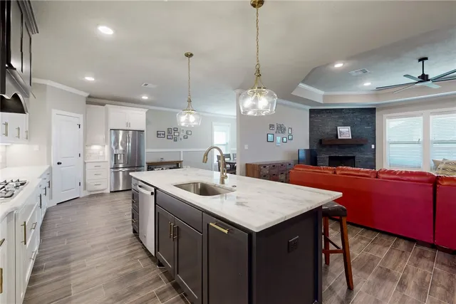 a large kitchen with stainless steel appliances a large center island attached withe living room