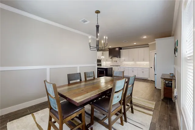 a view of a dining room with furniture wooden floor and chandelier