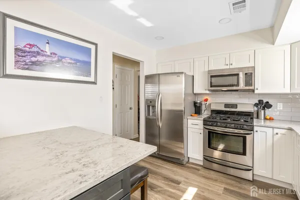 a kitchen with stainless steel appliances granite countertop a stove a refrigerator and a sink