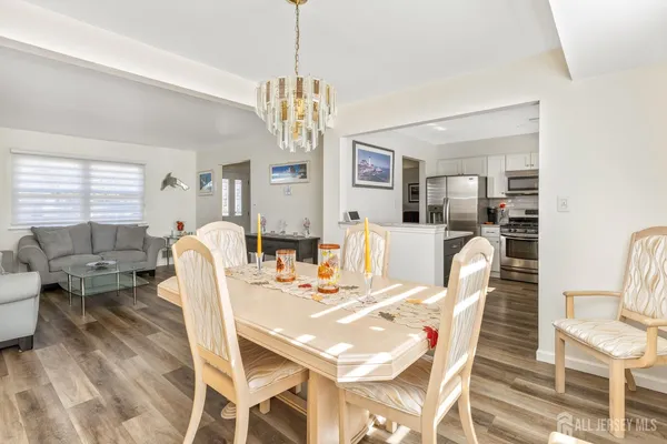 a view of a dining room with furniture a chandelier and wooden floor