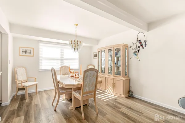a dining room with furniture a chandelier and wooden floor
