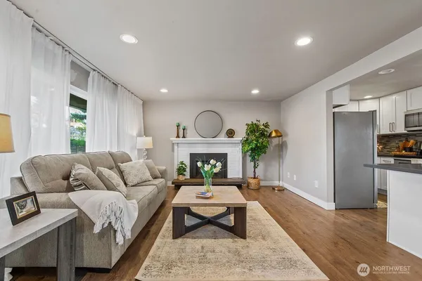 a living room with furniture a fireplace and a potted plant
