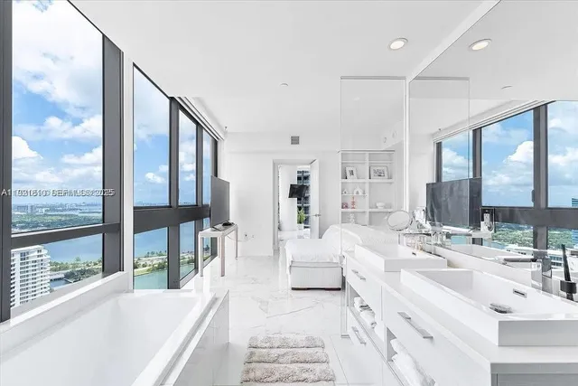 a bathroom with a tub sink and mirror