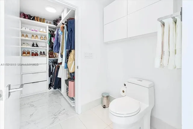 a white toilet sitting next to a white sink
