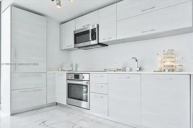 a kitchen with white cabinets and stainless steel appliances