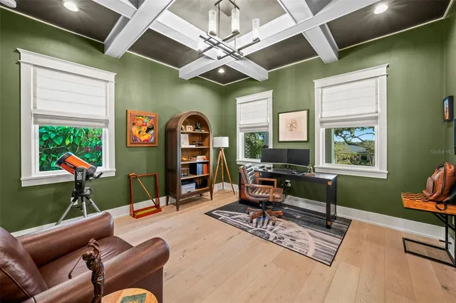 a work room with furniture a rug and a window