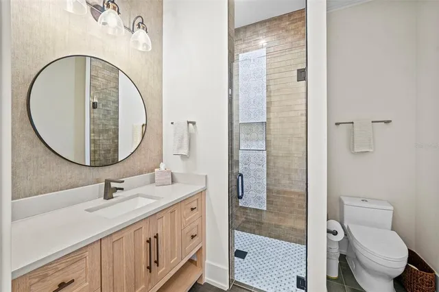 a bathroom with a granite countertop sink mirror vanity and toilet