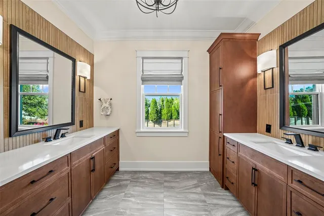 a bathroom with a double vanity sink a mirror and a bathtub