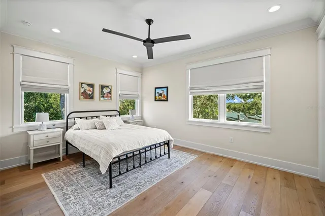 a bedroom with a large bed chandelier and a window