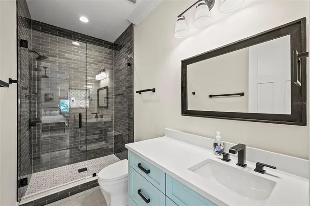 a bathroom with a sink mirror toilet and shower