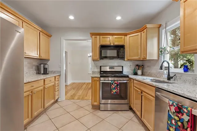a kitchen with stainless steel appliances granite countertop a stove sink and cabinets