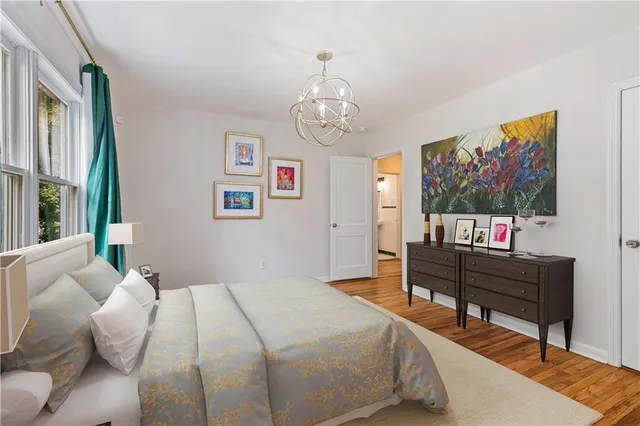 a bedroom with a bed and a dresser next to a window