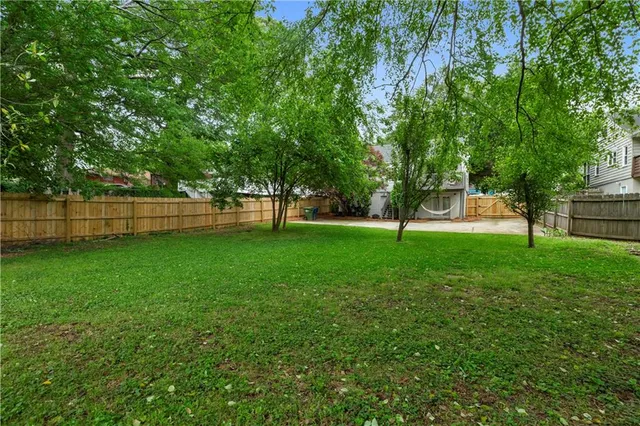 a view of a small house with potted plants and large trees