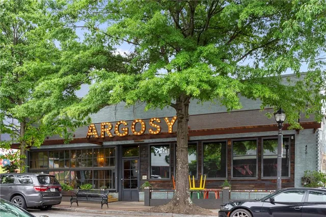 a sign board with buildings in the background