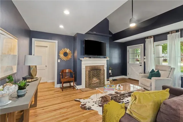 a living room with furniture a flat screen tv and a fireplace