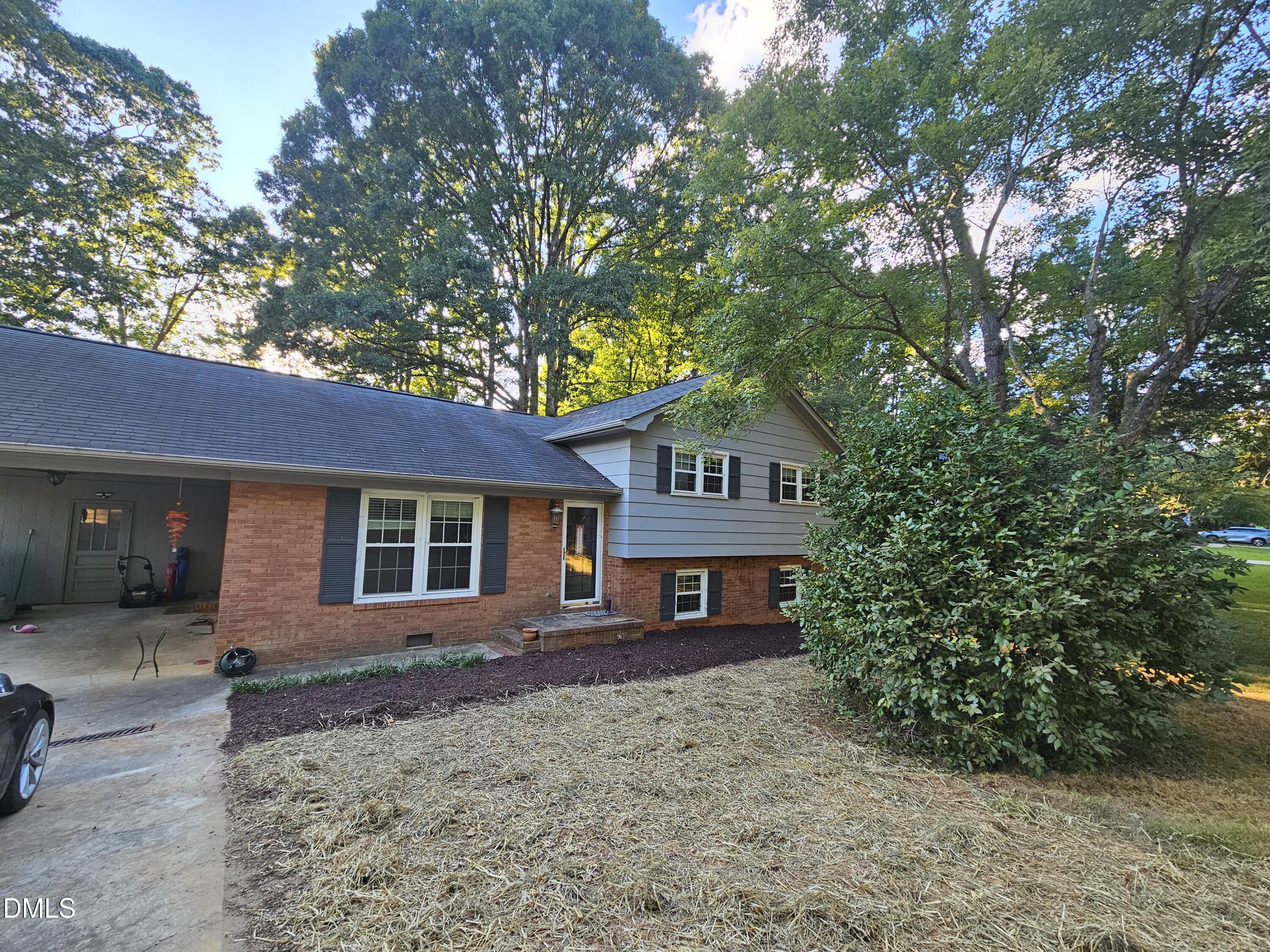 a view of a house with a yard and large tree