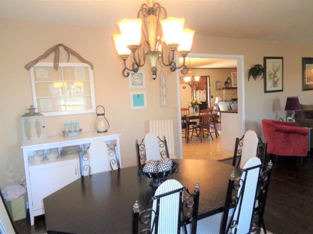 2069 Fall River Road Leoma, TN 38468 - Photo 5 of 26 a dining room with wooden floor a chandelier a wooden table and chairs