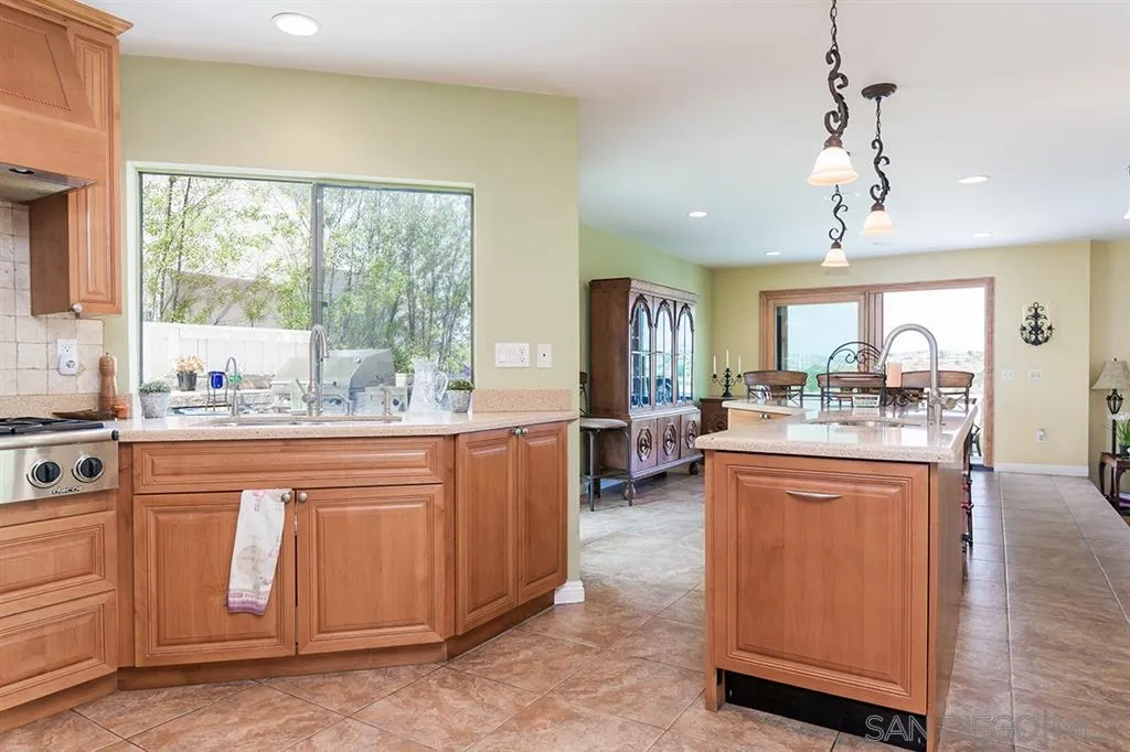 1717 Gascony Road Encinitas, CA 92024 - Photo 9 of 25 a large kitchen with kitchen island granite countertop a stove a sink and a refrigerator
