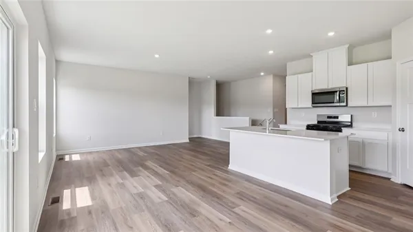 a kitchen with wooden floors and white appliances