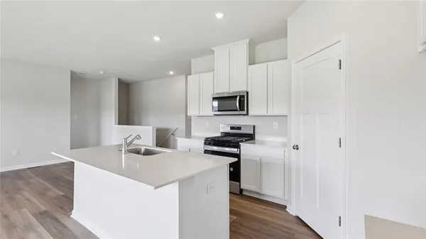 a kitchen with appliances a sink cabinets and wooden floor
