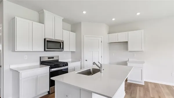 a kitchen with white cabinets a sink and appliances
