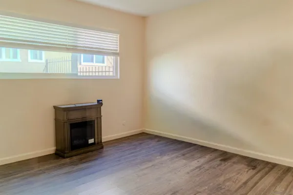 an empty room with wooden floor and a window