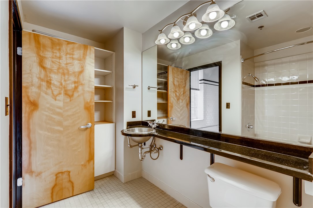710 Colorado Street, Unit 4J Austin, TX 78701 - Photo 19 of 37 Large full bath with granite counter, linen storage, tile shower over tub.