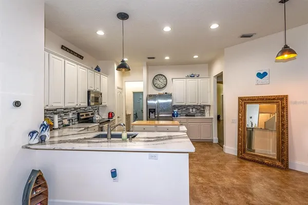 a kitchen with kitchen island a sink stainless steel appliances and cabinets