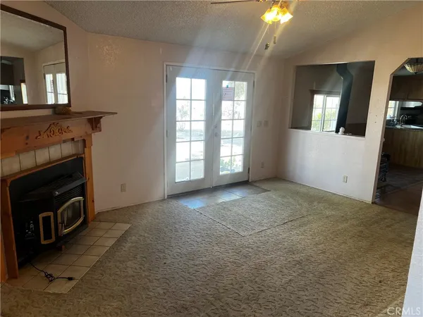 a view of an empty room with a fireplace and a window